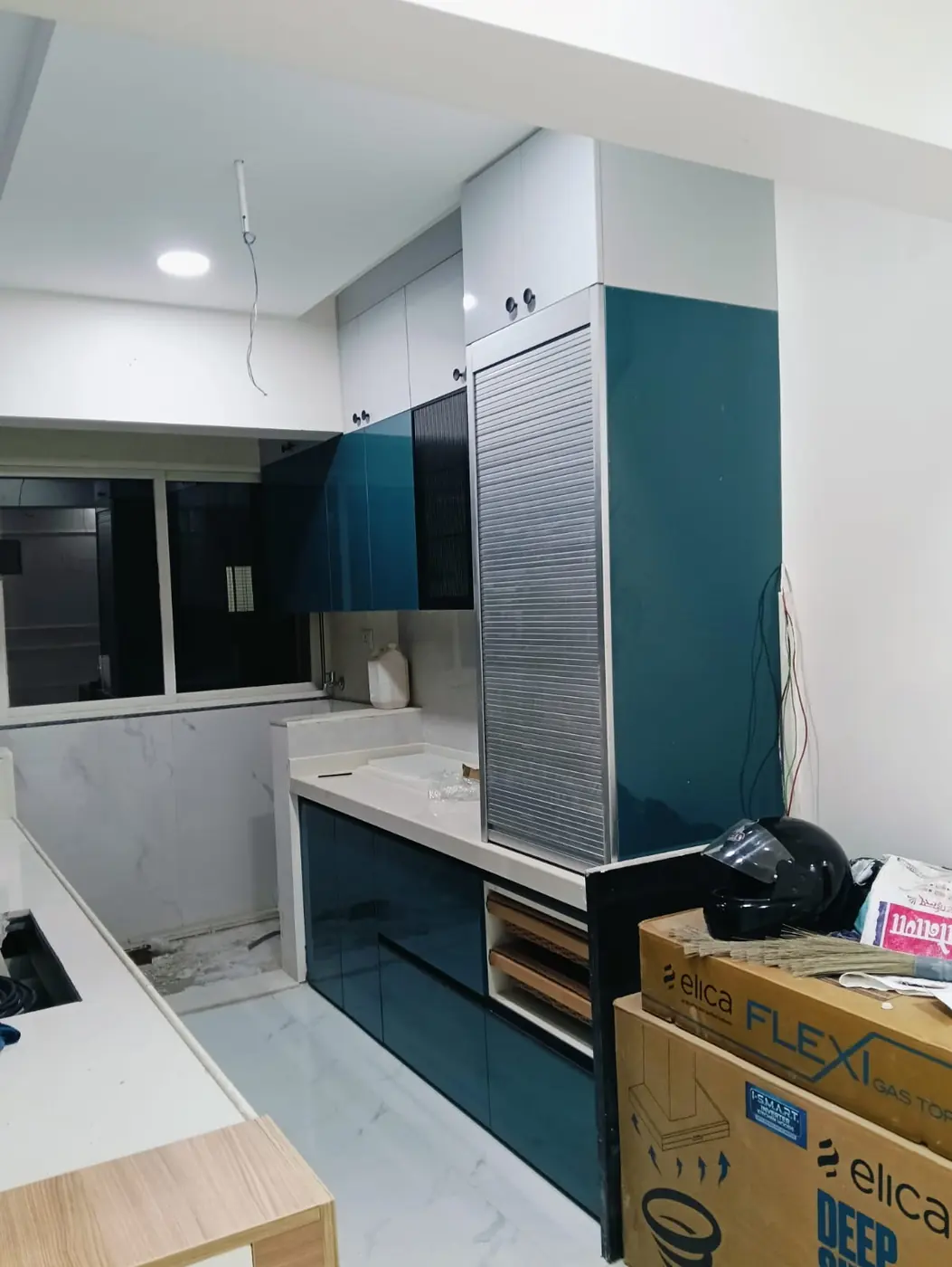 Teal high-gloss acrylic modular kitchen with tambour tall unit, Pune