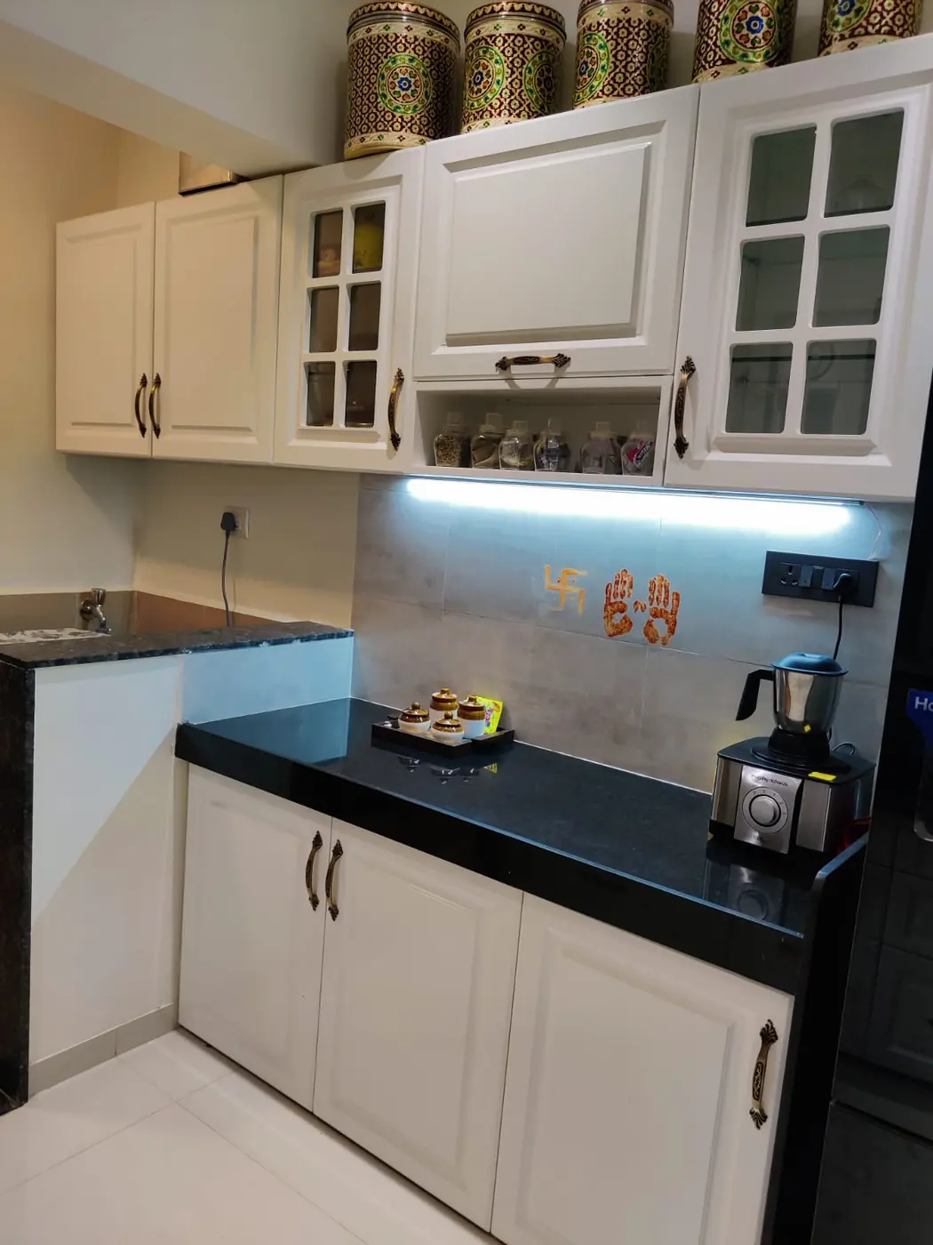 White shaker modular kitchen with glass shutters, lift-up unit and under-cabinet light, Pune